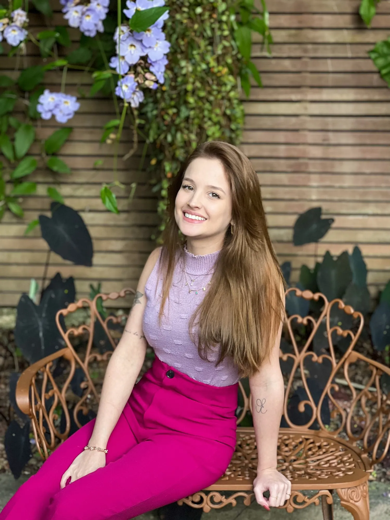 Lana Marques da Luz, psicóloga e Gestalt-terapeuta, sentada em um banco de jardim